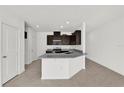 Modern kitchen featuring granite countertops, dark cabinetry and stainless steel appliances at 375 Sequoia Dr, Lake Wales, FL 33859