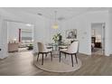 Open-concept dining room with a glass-top table, modern chairs, and views into the living room and bedroom at 4112 Aberdeen Ln, Lake Wales, FL 33859