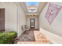 Inviting front porch with brick pavers, adorned with a decorative pink metal wall art piece and comfortable seating at 4112 Aberdeen Ln, Lake Wales, FL 33859