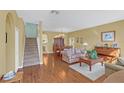 Open-concept living room featuring wood floors, stairs, and ample natural light at 497 Lakepark Trl, Oviedo, FL 32765