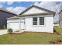 Well-maintained home with lush green lawn, gray trim, and a two-car garage at 5715 Cattle Ranch Dr, Saint Cloud, FL 34771