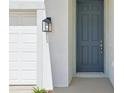 Close-up of a contemporary-style front door with modern lantern at 5715 Cattle Ranch Dr, Saint Cloud, FL 34771