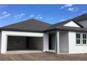 New construction home with open garage and gray accents at 5723 Cattle Ranch Dr, Saint Cloud, FL 34771