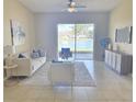 Bright living room showcasing tile floors, neutral paint, ceiling fan, and sliding glass door with pond view at 12859 Enclave Dr, Orlando, FL 32837