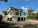 Exterior view of a modern new home with an elevated foundation, featuring spacious garages underneath at 1309 Errol Green Ct, Apopka, FL 32712