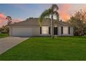 Tan one-story house with garage and palm tree in front at 1712 Whipple Dr, Deltona, FL 32738