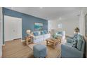 Stylish living room with a blue accent wall, comfortable seating, and tasteful decor at 7833 Oak Reflection Loop, Davenport, FL 33837