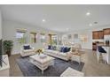 Bright living room with large windows, plush seating, and an open floor plan leading to the dining area at 7833 Oak Reflection Loop, Davenport, FL 33837