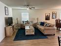 Comfortable living room features stylish furniture, a ceiling fan, and tasteful decor at 2325 Crossandra St, Mascotte, FL 34753