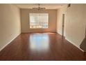 Bright living room with wood floors, ceiling fan, and natural light from a large window at 5542 Metrowest Blvd # 206, Orlando, FL 32811