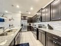 Modern kitchen with dark cabinets, granite countertops, and stainless steel appliances at 826 Paradise Dr, Davenport, FL 33897