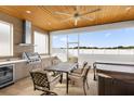 This outdoor kitchen features modern appliances, grill, beverage center, and a dining set for luxury outdoor living at 12608 Ne 49Th Dr, Oxford, FL 34484