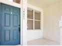 Inviting front porch featuring a teal door and a window, creating a warm entry at 14480 Chinese Elm Dr, Orlando, FL 32828