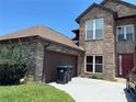 Two-story brick house with a brown roof, attached garage, and a long driveway at 2355 Abalone Blvd, Orlando, FL 32833