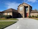 Two story brick home with a well-manicured lawn, a two car garage, and a curved driveway at 2355 Abalone Blvd, Orlando, FL 32833