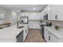 Modern kitchen with quartz countertops, stainless steel appliances, and sleek white cabinetry at 10157 Spring Lake Dr, Clermont, FL 34711