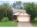 Charming home featuring a stone-accented facade, two-car garage, well-manicured lawn and beautiful tropical landscaping at 513 San Sebastian Ct, Davenport, FL 33837