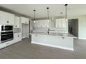A kitchen features white cabinets, a spacious island, and stainless steel appliances at 977 Hawksnest Pt, Oviedo, FL 32765