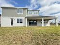 Back exterior of a two-story home featuring an outdoor patio, large windows and a well-maintained lawn at 987 Hawksnest Pt, Oviedo, FL 32765