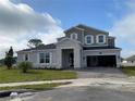 Charming two-story home with gray siding, stone accents, manicured lawn, and spacious driveway at 987 Hawksnest Pt, Oviedo, FL 32765