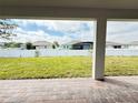 View from the covered patio out to a well-manicured lawn and privacy fence at 987 Hawksnest Pt, Oviedo, FL 32765