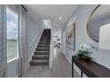 Spacious entryway with staircase and natural light, showcasing tile flooring and modern decor at 3316 Thicket St, Tavares, FL 32778