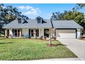 Charming ranch home with a gray roof, white exterior, and landscaping at 4034 Winderlakes Dr, Orlando, FL 32835