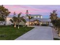 Beautifully landscaped home with a long drive, metal roof, and inviting covered entryway at 25 Cunningham Dr, New Smyrna Beach, FL 32168