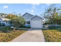 Gray house with a driveway and attached garage, surrounded by lush landscaping at 250 Silas Phelps Ct, Orlando, FL 32828