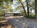 Ranch-style home with attached garage, surrounded by trees at 2663 Magnolia Rd, Deland, FL 32720