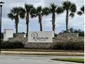 The Reserve at Twin Lakes community entrance with stonework and palm trees at 2813 Willowseed Ln, Saint Cloud, FL 34772
