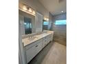 Elegant bathroom boasts double vanity, large shower, and modern fixtures at 2817 Willowseed Ln, Saint Cloud, FL 34772