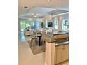 Open-concept living area featuring dining, and kitchen with granite counters at 7652 Whisper Way # 104, Reunion, FL 34747