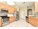 Bright kitchen featuring stainless steel appliances, wood cabinets, and tile flooring for easy maintenance at 77 Spring Glen Dr, Debary, FL 32713