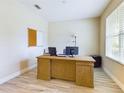 Home office with a large wooden desk, two computer monitors, and a corkboard at 2506 Volunteer Ave, Kissimmee, FL 34744
