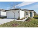New single-story house with attached garage, teal door, and walkway at 2534 Linda Knoll Ln, Bartow, FL 33830