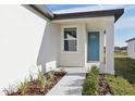 Front entry with teal door and landscaped walkway at 2534 Linda Knoll Ln, Bartow, FL 33830