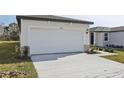 White double-car garage with stone accents at 2534 Linda Knoll Ln, Bartow, FL 33830