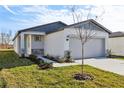 New construction home with gray garage door and a light-colored exterior at 2538 Linda Knoll Ln, Bartow, FL 33830