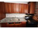 An updated kitchen with granite counters, wood cabinets and stainless steel appliances at 1040 Santa Anita St, Orlando, FL 32808