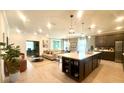 A spacious kitchen with a large island, pendant lighting, and seamless flow into the living and dining areas at 1664 Andover Ridge Dr, Deland, FL 32720