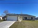 Newly built house featuring a two-car garage and well-maintained lawn at 199 Juniper Way, Ocala, FL 34472
