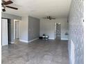 Spacious living room featuring neutral paint, ceiling fans and tile flooring at 2302 E Dana Dr, Deltona, FL 32738