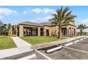 Side view of the community clubhouse showcasing patio, desert landscaping, and accessible parking at 3243 Arch Ave, Ormond Beach, FL 32174