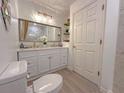 Bright bathroom featuring a double sink vanity with white cabinets, modern fixtures, and framed mirror at 3258 Cranston St, Deltona, FL 32738