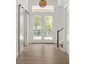 Bright entryway with light wood floors, white doors, and a stylish light fixture at 531 Sanctuary Golf Pl, Apopka, FL 32712