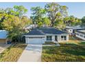 A single Gathering home with a dark roof, a wide driveway, and a two-car garage at 765 W Lansdowne Ave, Orange City, FL 32763