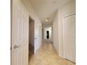 Hallway with neutral walls, tile flooring, and white doors and trim, leading to other rooms in the home at 8343 Bella Tierra Ct # 8343, Davenport, FL 33896