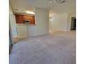 Open living area with carpeted floors and an eat-in kitchen featuring wood cabinets at 8343 Bella Tierra Ct # 8343, Davenport, FL 33896