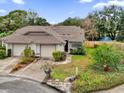 Aerial view of a tan house with a brown roof and a backyard at 2682 Orange Peel Ct, Orlando, FL 32806